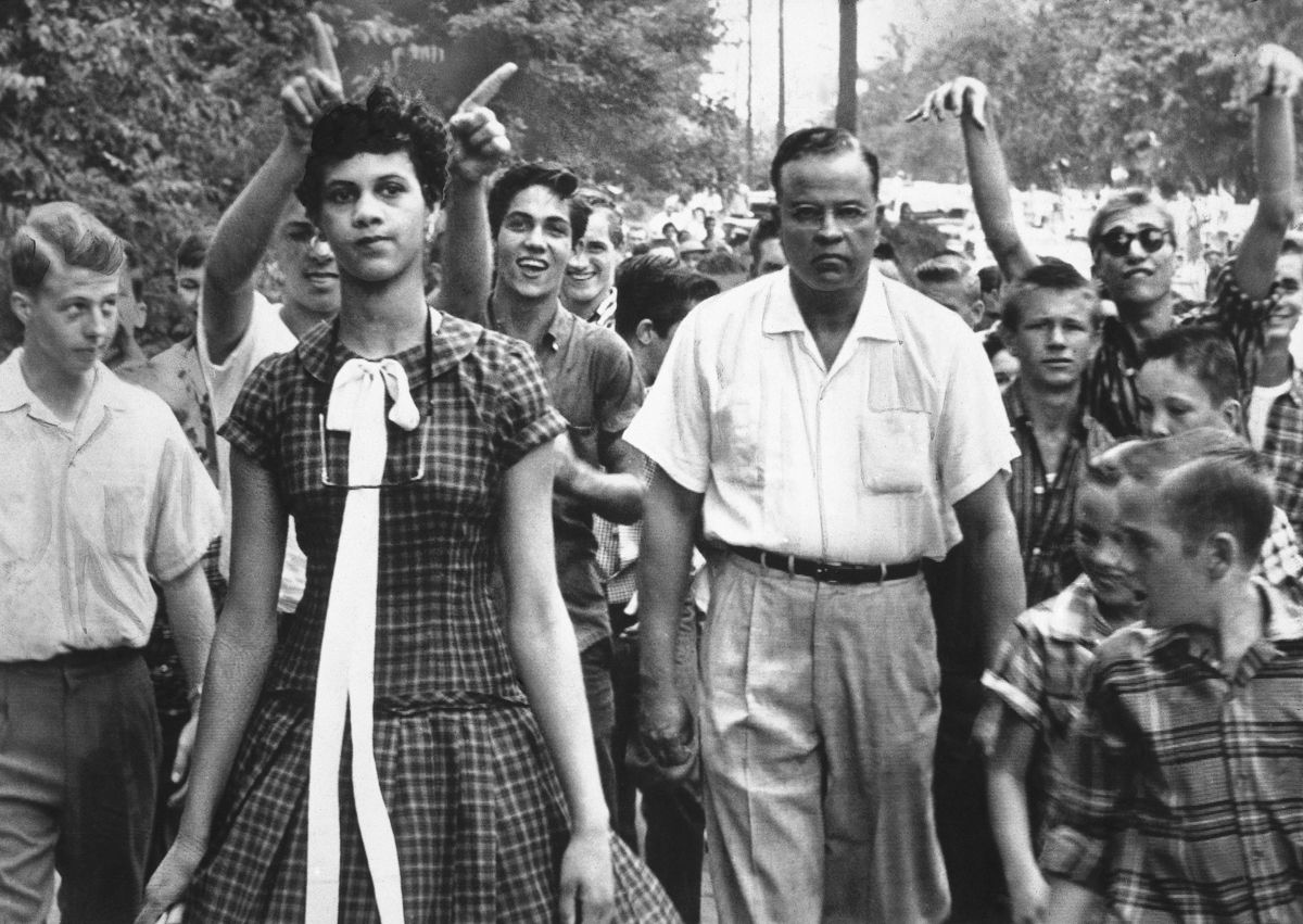 Dorothy Counts walks into Harry Harding High School on her first day, September 4, 1957, as a crowd looks on.