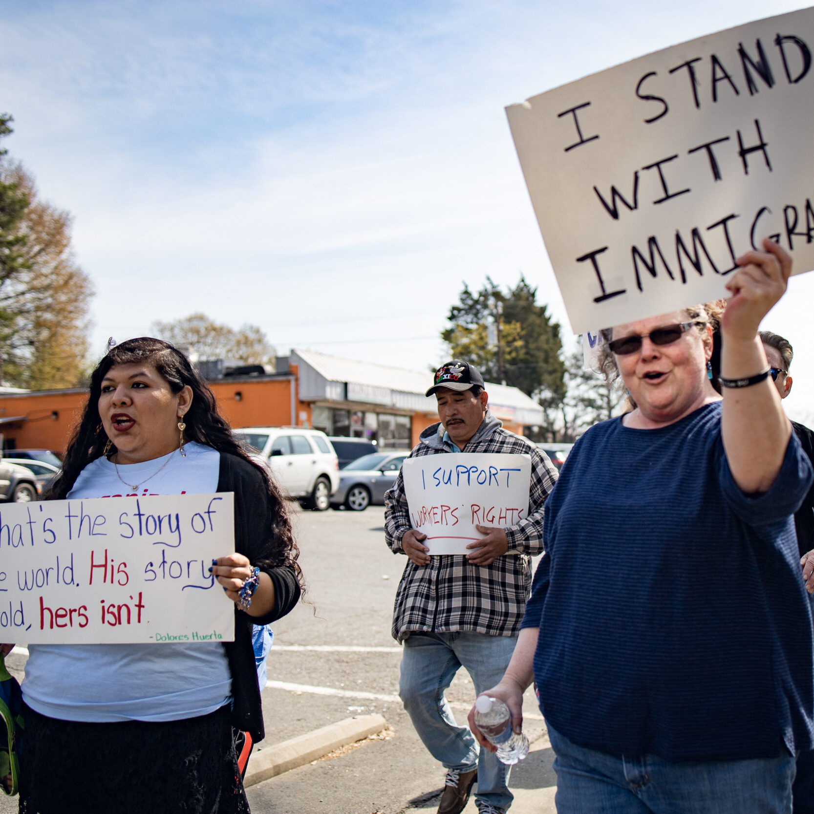 Action NC protestors hold up signs with pro-immigrant messages